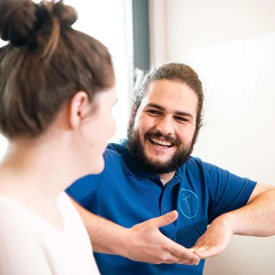 Dozent der Johannesbad Massageschule erklärt Schülerin einen Handgriff