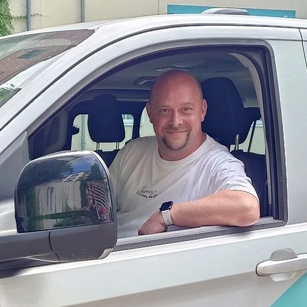 Fahrer Maik Grimmert sitzt in einem Auto und blickt aus dem Fenster. Fahrer Maik Grimmert sitzt in einem Auto und blickt aus dem Fenster.