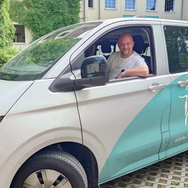 Fahrer Maik Grimmert sitzt in einem Auto und blickt aus dem Fenster.
