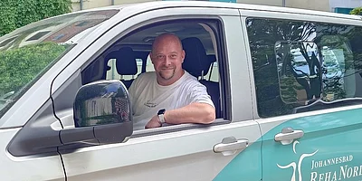 Fahrer Maik Grimmert sitzt in einem Auto und blickt aus dem Fenster.