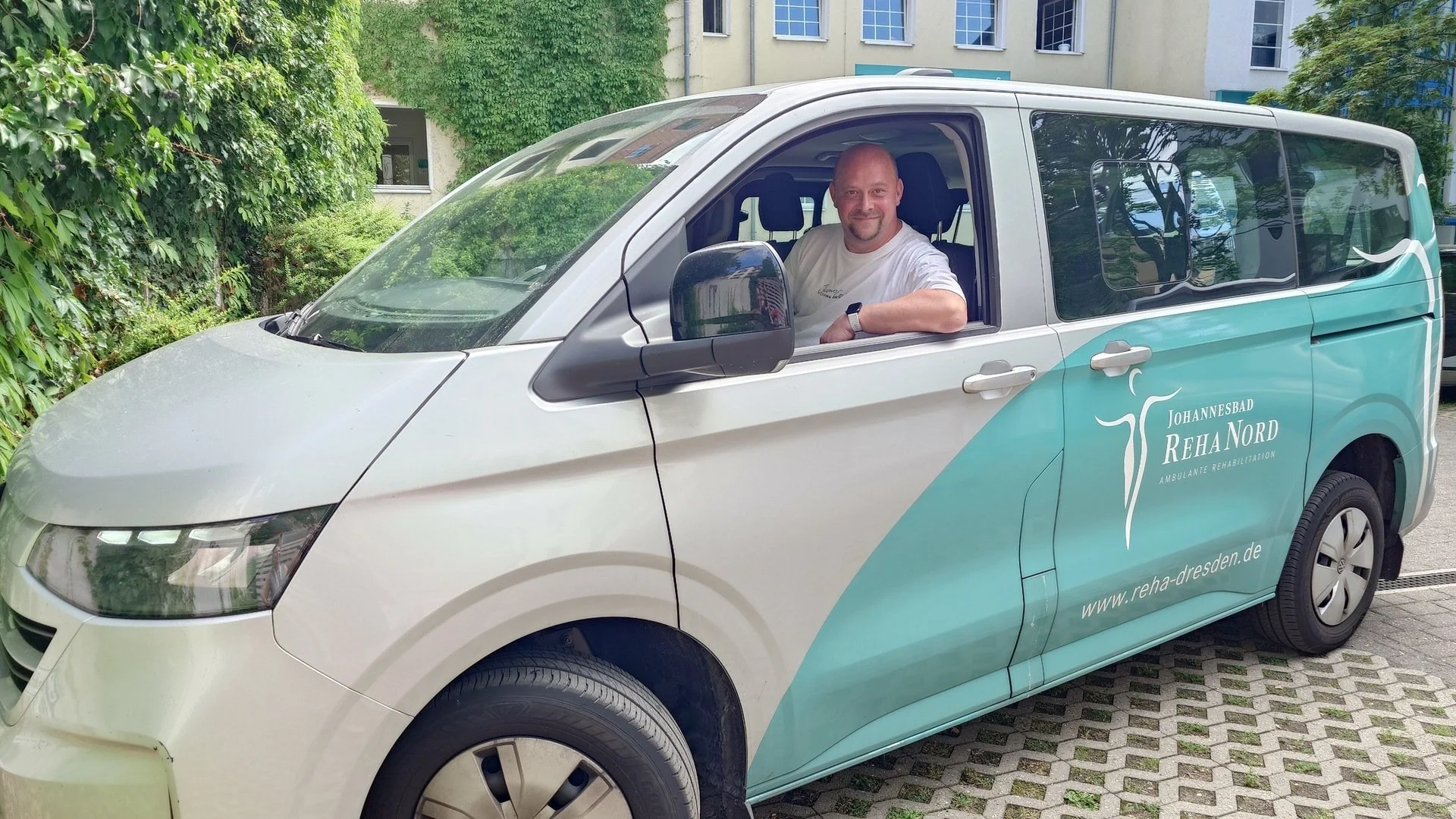 Fahrer Maik Grimmert sitzt in einem Auto und blickt aus dem Fenster.