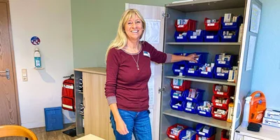 Nicole Kiefer steht in einem Büro und lächelt in die Kamera