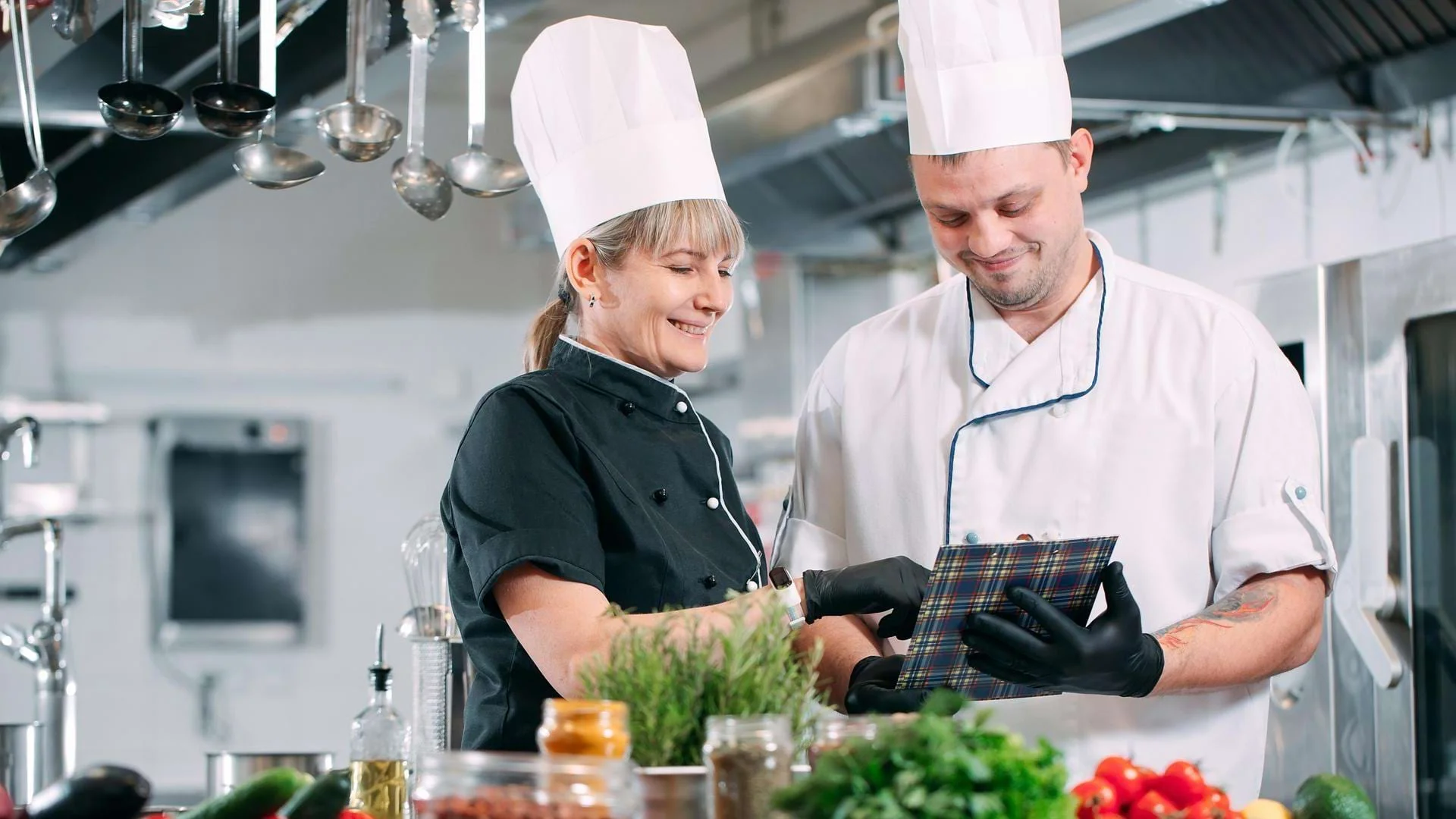 Auszubildende Köche kochen gemeinsam in der Küche., Bild öffnen