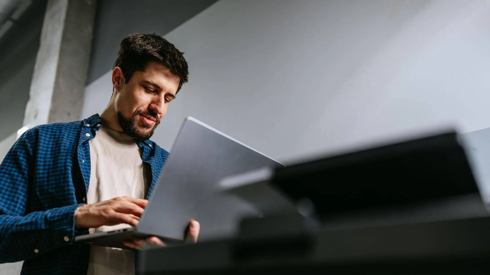 Informatiker steht an Drucker