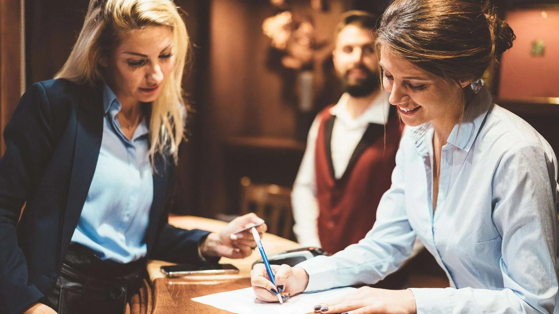 Fachkraft für Restaurants und Veranstaltungsgastronomie arbeitet am Empfang und betreut Gäste. Fachkraft für Restaurants und Veranstaltungsgastronomie arbeitet am Empfang und betreut Gäste., Bild öffnen