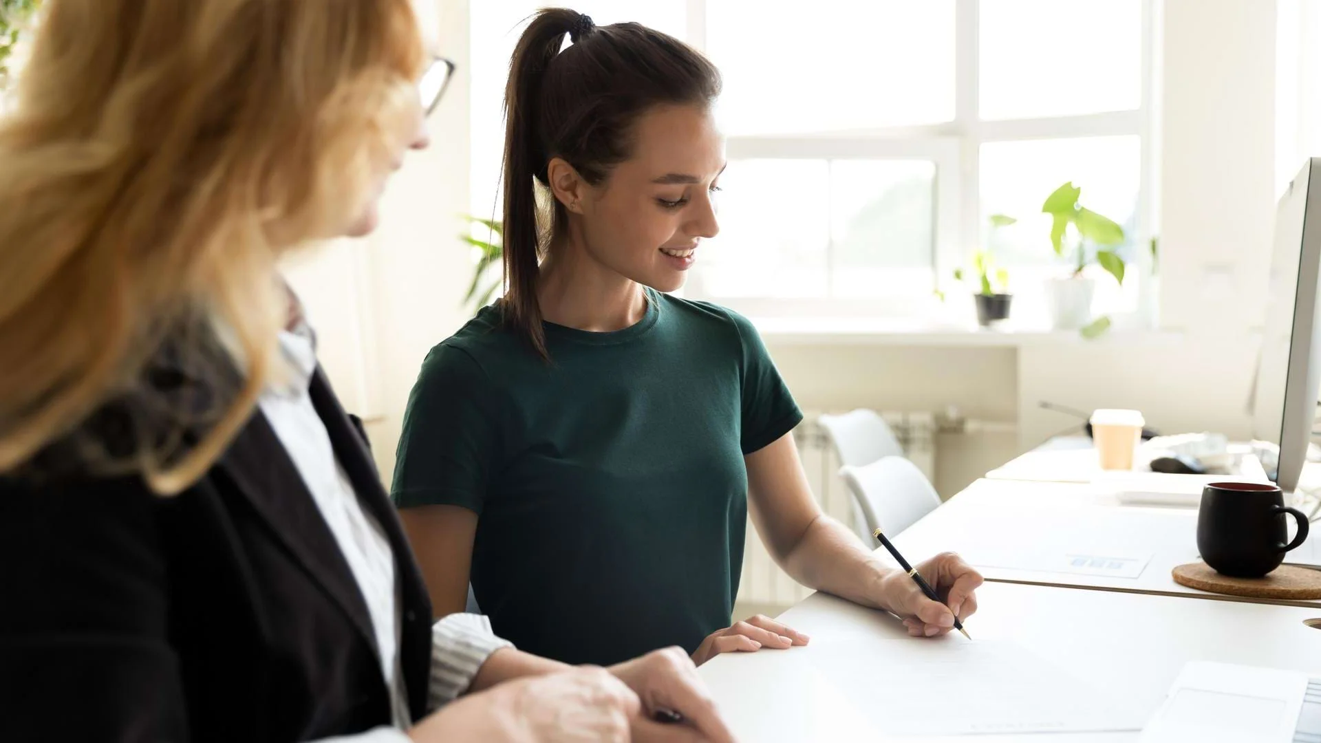 Auszubildende Kauffrau für Büromanagement arbeitet mit ihrer Ausbilderin zusammen. Auszubildende Kauffrau für Büromanagement arbeitet mit ihrer Ausbilderin zusammen., Bild öffnen