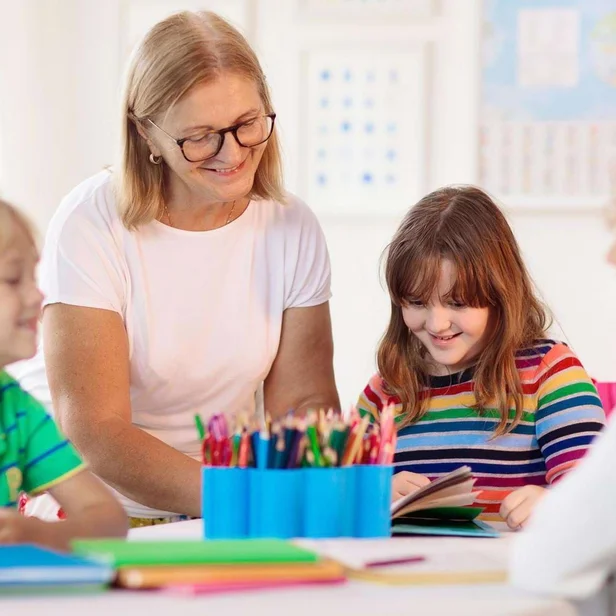 Kinderpflegerin betreut mehrere Kinder beim gemeinsamen Spielen. Kinderpflegerin betreut mehrere Kinder beim gemeinsamen Spielen.