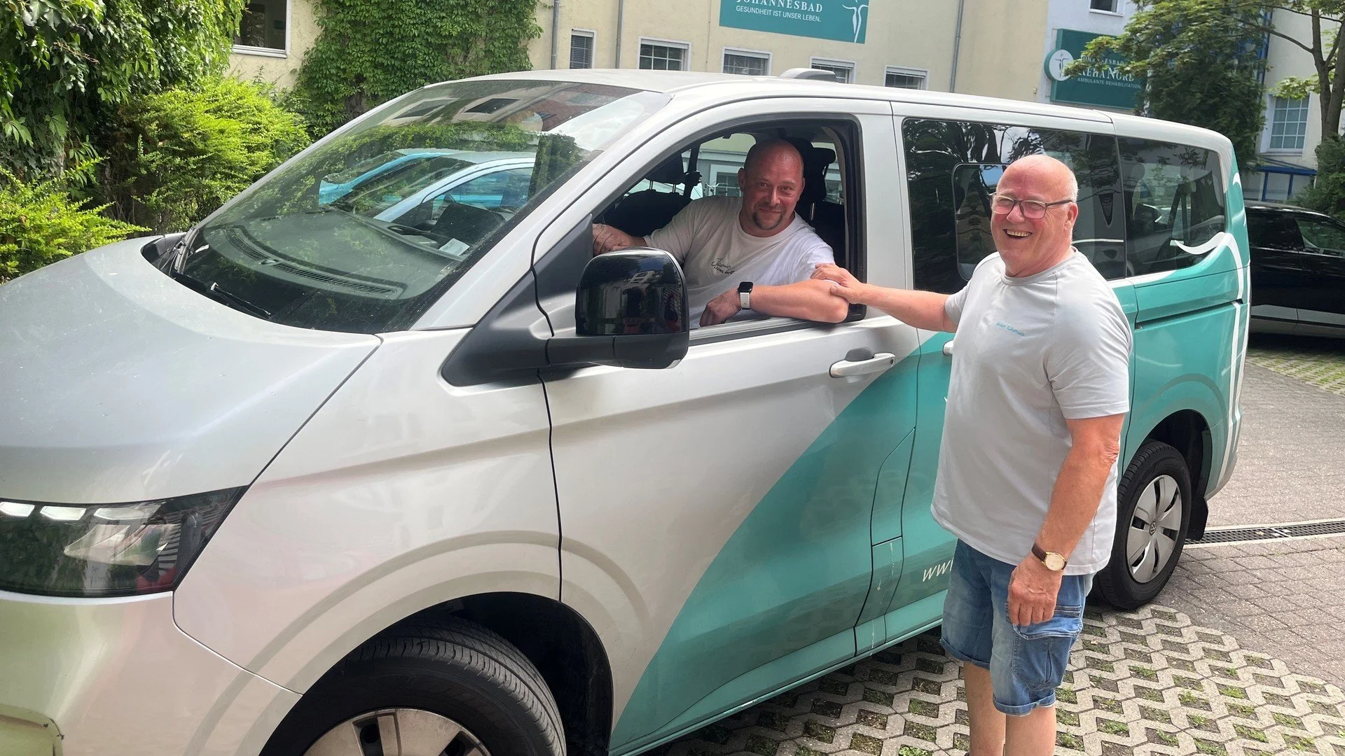 Fahrer Maik Grimmert sitzt im Auto und unterhält sich mit einem Kollegen.