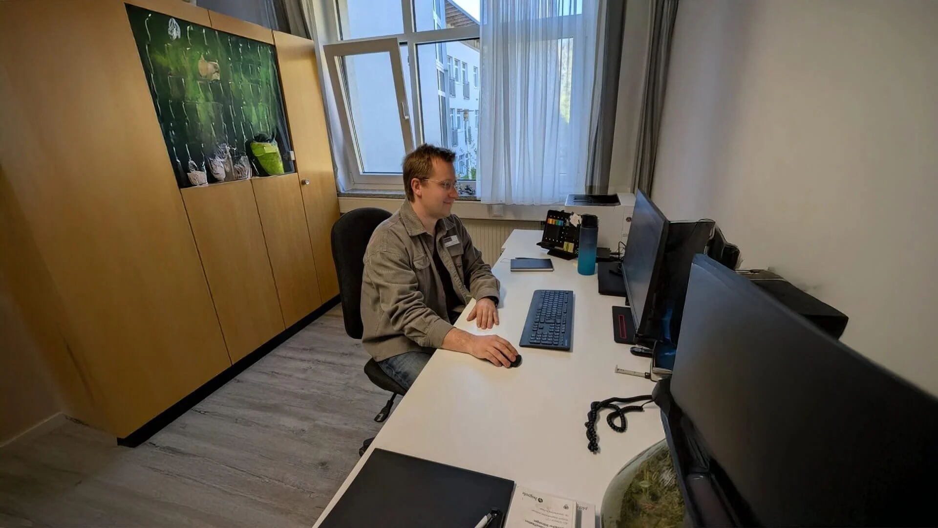 Simon Lössl, Psychologe, sitzt an seinem Schreibtisch und blickt auf einen Bildschirm.