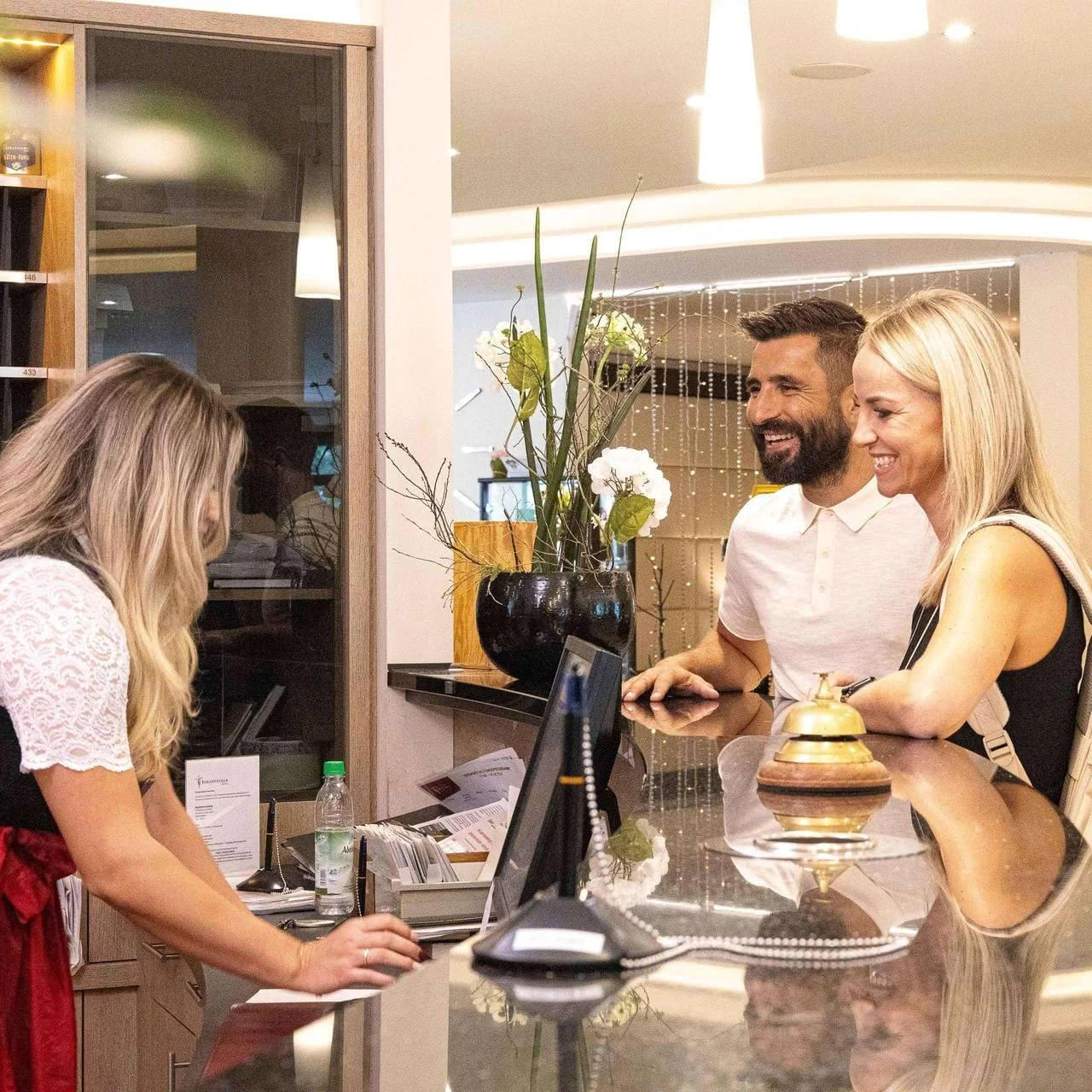 Rezeptionistin der Johannesbad Hotels mit Pärchen beim Check-in