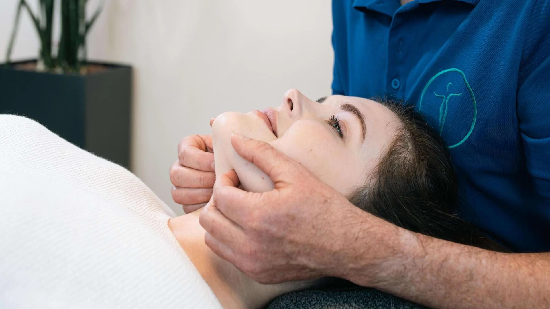 Ausbilder zeigt Handgriffe am Kopf einer Patientin während der Fortbildung Manuelle Therapie., Bild öffnen