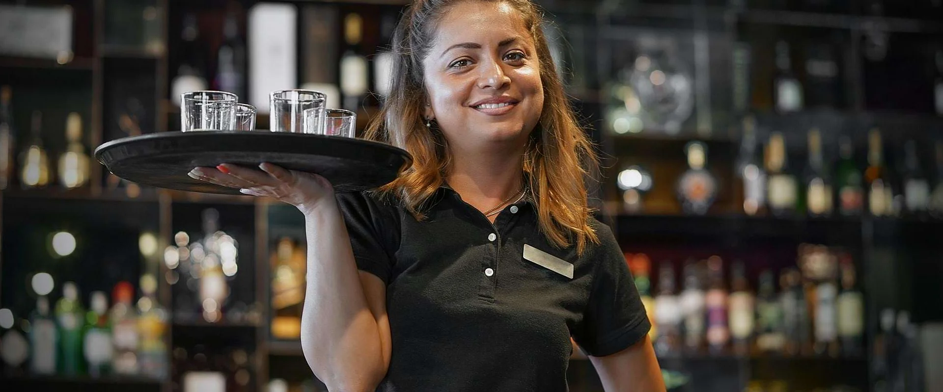 Eine Auszubildende zur Fachkraft für Gastronomie arbeitet mit Tablet im Service. Eine Auszubildende zur Fachkraft für Gastronomie arbeitet mit Tablet im Service.